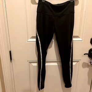 Victoria’s Secret Sport Black leggings with silver side stripe. Size M
